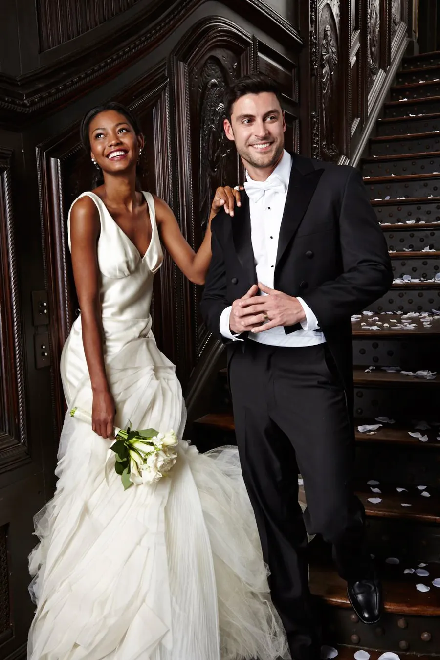 Couple in black tails and a white gown on a grand staircase
