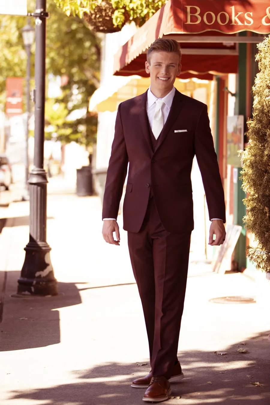 Man in a burgundy three piece suit walking downtown